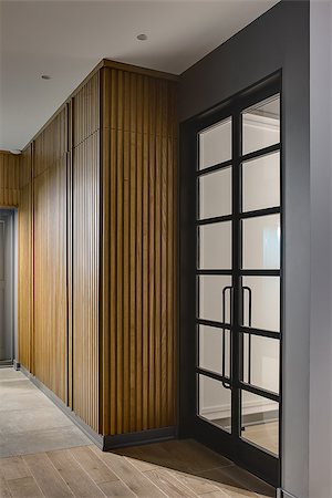 Glowing hall in a modern style with gray walls and tiles with a parquet on the floor. There is a large wooden wardrobe, gray door and glass black door. Vertical. Stock Photo - Budget Royalty-Free & Subscription, Code: 400-08832535