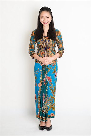 Portrait of young southeast Asian girl in traditional Malay batik kebaya dress smiling, full body standing on plain background. Stock Photo - Budget Royalty-Free & Subscription, Code: 400-08832767