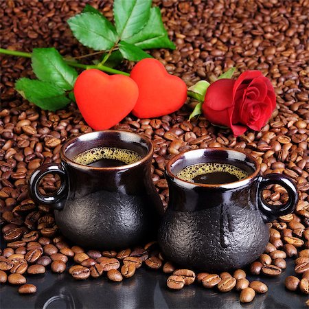 Two cups of black coffee with foam on the background from the fried coffee beans, small hearts and a red rose. For cards for Valentine's Day. Stock Photo - Budget Royalty-Free & Subscription, Code: 400-08833034