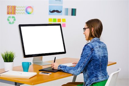 Woman working at desk In a creative office, using a computer Foto de stock - Super Valor sin royalties y Suscripción, Código: 400-08864225
