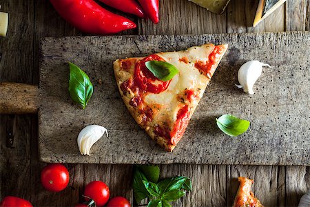 simsearch:400-04539943,k - Pizza slice on wood with ingredients. Pizza with cheese, tomatoes and basil. Rustic italian pizza Stockbilder - Microstock & Abonnement, Bildnummer: 400-08864527