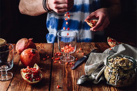 seva_blsv (artist) - Man Puts Pomegranate Seeds into the Glass. Series on Prepare Healthy Dessert with Pomegranate, Granola, Cream and Jam Stock Photo - Budget Royalty-Free & Subscription, Code: 400-08864555