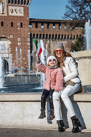 family portrait with flags - Rediscovering things everybody love in Milan. Full length portrait of happy modern mother and daughter tourists in sunglasses in Milan, Italy rising flag Stock Photo - Budget Royalty-Free & Subscription, Code: 400-08864697