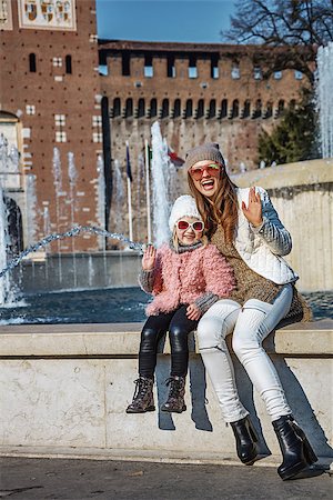 simsearch:400-08864986,k - Rediscovering things everybody love in Milan. Full length portrait of smiling modern mother and daughter tourists in sunglasses near Sforza Castle in Milan, Italy handwaving Stock Photo - Budget Royalty-Free & Subscription, Code: 400-08864693