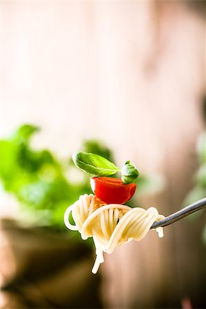 simsearch:400-08115563,k - Italian cuisine. Pasta on fork. Pasta with olive oil, garlic, basil and tomatoes. Spaghetti with tomatoes Photographie de stock - Aubaine LD & Abonnement, Code: 400-08864789