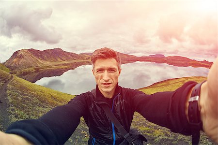 man hiker photographer taking selfie on the lake background in Iceland Stockbilder - Microstock & Abonnement, Bildnummer: 400-08865139