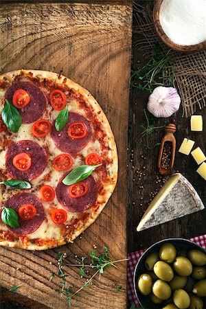 simsearch:400-08107342,k - Fresh italian  pizza on wood. Pizza with cheese, salami and tomatoes. Fast food. Rustic pizza Stock Photo - Budget Royalty-Free & Subscription, Code: 400-08861256