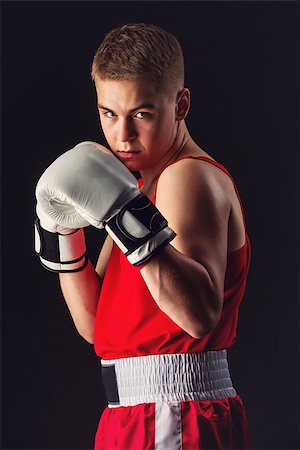 svetography (artist) - Young handsome boxer sportsman in red boxer suit and white gloves standing on black backgound. Copy space. Foto de stock - Royalty-Free Super Valor e Assinatura, Número: 400-08861356