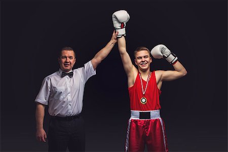Boxing referee gives medal to young teen boxer in red form and white gloves. Winner. Studio shot on black background. Copy space. Stock Photo - Budget Royalty-Free & Subscription, Code: 400-08861363