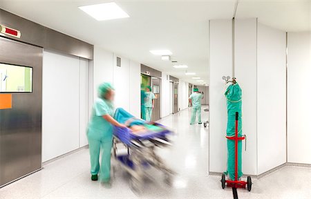 pushing door - Modern hospital surgery corridor with motion blurred figures of personnel wearing medical uniforms with an emergency bed on wheels. Stock Photo - Budget Royalty-Free & Subscription, Code: 400-08861923