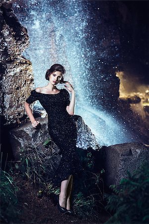 fotolit (artist) - Beautiful woman in black dress posing near waterfall Foto de stock - Royalty-Free Super Valor e Assinatura, Número: 400-08861988