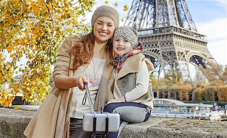 simsearch:400-09031587,k - Autumn getaways in Paris with family. smiling mother and child travellers on embankment in Paris, France taking selfie using selfie stick Stock Photo - Budget Royalty-Free & Subscription, Code: 400-08863321