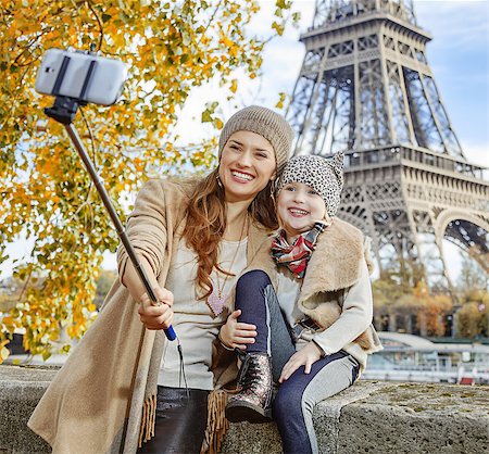 simsearch:400-09031587,k - Autumn getaways in Paris with family. happy mother and child tourists on embankment near Eiffel tower in Paris, France taking selfie using selfie stick Stock Photo - Budget Royalty-Free & Subscription, Code: 400-08863323