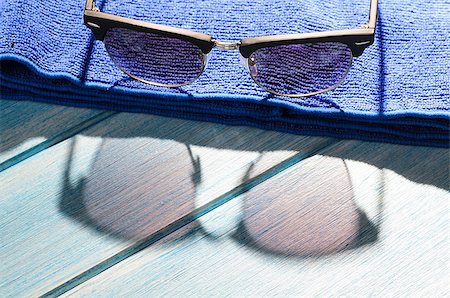 simsearch:400-04855630,k - stylish sunglasses and towel on blue wooden table with sunlight Foto de stock - Royalty-Free Super Valor e Assinatura, Número: 400-08863514