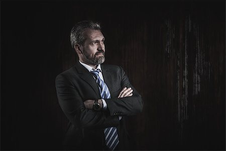 senior dark background - Portrait of a mature businessman in a black suit on dark background Stock Photo - Budget Royalty-Free & Subscription, Code: 400-08863579