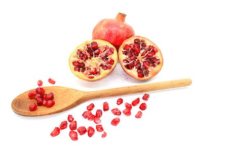 simsearch:640-02656973,k - Whole red pomegranate and two cut halves with some seeds removed with a wooden spoon, isolated on a white background Fotografie stock - Microstock e Abbonamento, Codice: 400-08863998