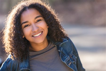 Outdoor portrait of beautiful happy mixed race African American girl teenager female young woman smiling laughing with perfect teeth Stock Photo - Budget Royalty-Free & Subscription, Code: 400-08887986