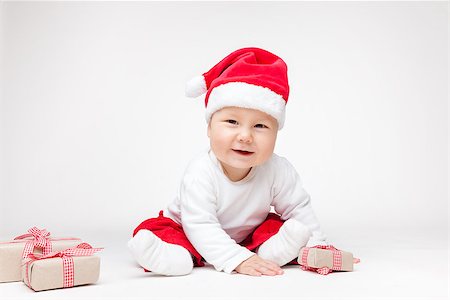 simsearch:400-09222788,k - Adorable young baby boy wearing a Santa hat opening Christmas presents Photographie de stock - Aubaine LD & Abonnement, Code: 400-08888065