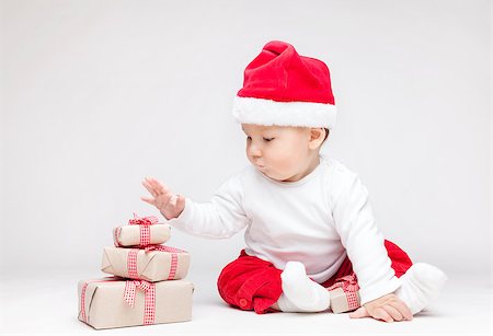 simsearch:400-09222788,k - Adorable young baby boy wearing a Santa hat opening Christmas presents Photographie de stock - Aubaine LD & Abonnement, Code: 400-08888062