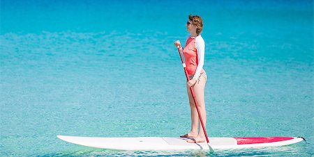 young woman enjoying stand up paddling, active and healthy summer vacation activity Foto de stock - Super Valor sin royalties y Suscripción, Código: 400-08888153