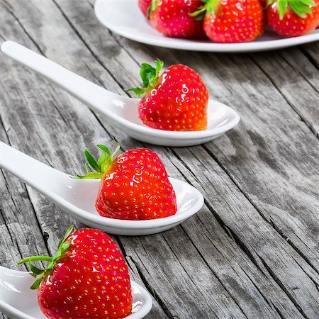 strawberries on a porcelain spoons on an old rustic table Stock Photo - Budget Royalty-Free & Subscription, Code: 400-08888299
