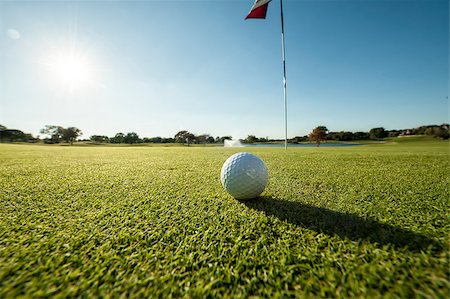 simsearch:400-03975619,k - Image of a Golf ball on green shot from a low angle and close to flag Stock Photo - Budget Royalty-Free & Subscription, Code: 400-08888335