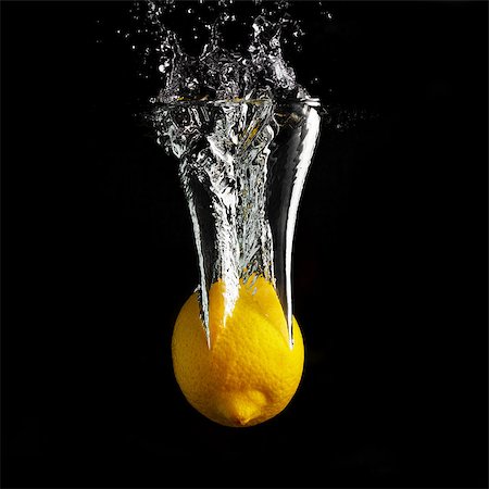 simsearch:622-07519502,k - Fresh yellow lemon falling into the water with a splash and air bubbles. Healthy food on black background. Wash fruits. Stockbilder - Microstock & Abonnement, Bildnummer: 400-08889280