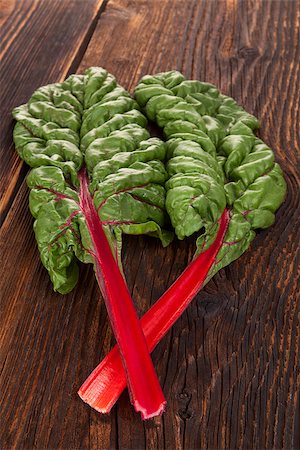 simsearch:6113-08985950,k - Fresh mangold leaves isolated on brown wooden rustic table. Healthy vegetable eating. Photographie de stock - Aubaine LD & Abonnement, Code: 400-08889552