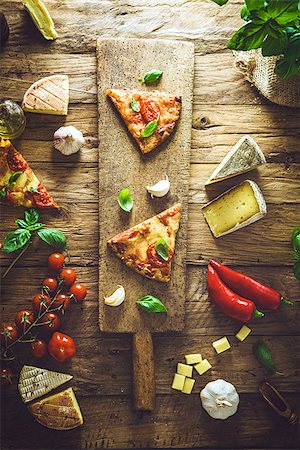 simsearch:400-04539943,k - Pizza slice on wood with ingredients. Pizza with cheese, tomatoes and basil. Rustic italian pizza Stockbilder - Microstock & Abonnement, Bildnummer: 400-08898866