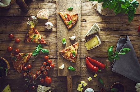 simsearch:400-04539943,k - Pizza slice on wood with ingredients. Pizza with cheese, tomatoes and basil. Rustic italian pizza Stockbilder - Microstock & Abonnement, Bildnummer: 400-08898867