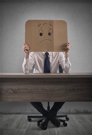 simsearch:400-08496169,k - Businessman in the office holds a cardboard with a sad face Stock Photo - Budget Royalty-Free & Subscription, Code: 400-08899537