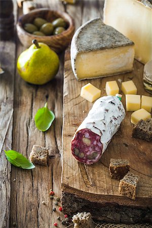 plate of cold cuts and cheeses - Cheese and Salami. Variety od cold cuts. Cheese on wood. Types of cheese and sausages Stock Photo - Budget Royalty-Free & Subscription, Code: 400-08899720
