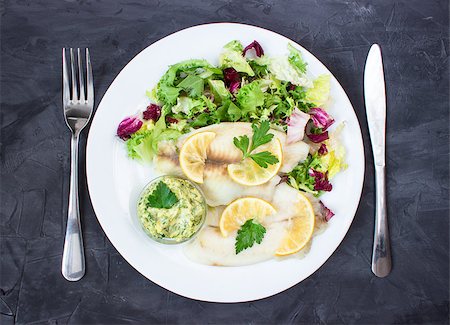 steamed tilapia fish with salad and tartar sauce with appliances on dark background. vertical Stock Photo - Budget Royalty-Free & Subscription, Code: 400-08890002