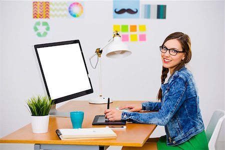 Woman working at desk In a creative office, using a computer Stock Photo - Budget Royalty-Free & Subscription, Code: 400-08890619
