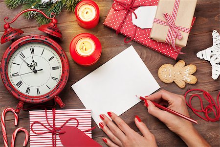 Female writing christmas greeting card and gift wrapping above wooden table. Top view with copy space Stock Photo - Budget Royalty-Free & Subscription, Code: 400-08890707