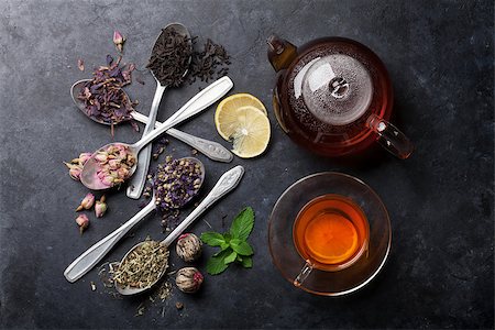 simsearch:622-09014216,k - Tea cup, teapot and assortment of dry tea in spoons on stone table. Top view Stockbilder - Microstock & Abonnement, Bildnummer: 400-08890713