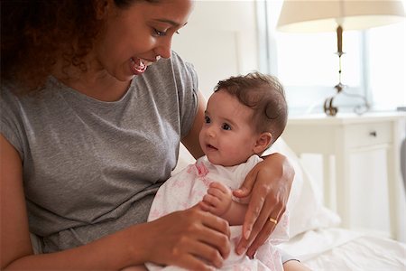 simsearch:400-08891803,k - Mother Cuddling Baby Daughter In Bedroom At Home Stock Photo - Budget Royalty-Free & Subscription, Code: 400-08891781