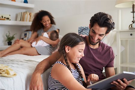 simsearch:400-08891803,k - Family With Baby Sitting In Bedroom Reading Book Stock Photo - Budget Royalty-Free & Subscription, Code: 400-08891796