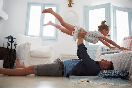 simsearch:400-08891803,k - Father Lifting Daughter Into The Air Indoors Stock Photo - Budget Royalty-Free & Subscription, Code: 400-08891871