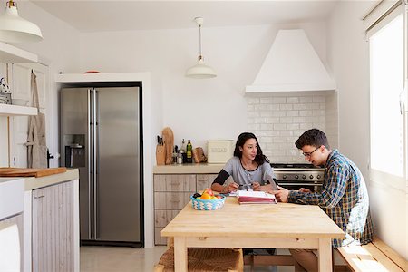 simsearch:400-08892339,k - Two teenagers using laptop study together at kitchen table Stock Photo - Budget Royalty-Free & Subscription, Code: 400-08892276