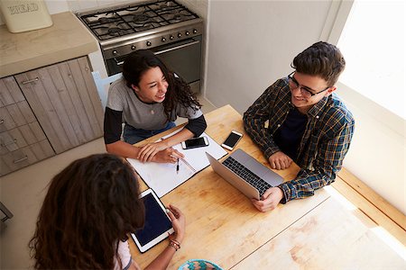 simsearch:400-08892368,k - Three teens study in kitchen using computers, elevated view Stock Photo - Budget Royalty-Free & Subscription, Code: 400-08892279