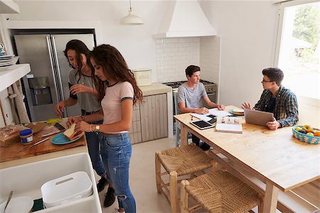 simsearch:400-08892339,k - Four teenagers making lunch and studying together in kitchen Stock Photo - Budget Royalty-Free & Subscription, Code: 400-08892285