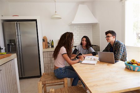 simsearch:400-08892368,k - Three teens talk as they study in a kitchen using a computer Stock Photo - Budget Royalty-Free & Subscription, Code: 400-08892282