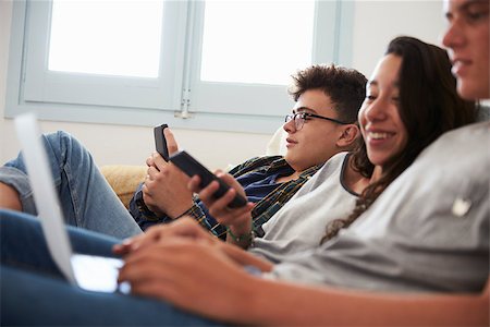 simsearch:400-08892339,k - Teenage friends relax watching laptop and smartphone at home Stock Photo - Budget Royalty-Free & Subscription, Code: 400-08892298