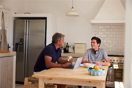 parent talking to their 16 year old - Dad and son using technology eat and talk at kitchen table Stock Photo - Budget Royalty-Free & Subscription, Code: 400-08892293