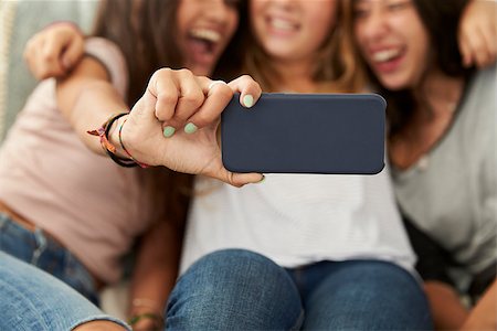 simsearch:614-06403026,k - Three teenage girls taking selfie at home, focus on phone Stock Photo - Budget Royalty-Free & Subscription, Code: 400-08892306