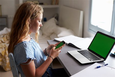 simsearch:400-08892339,k - Teenage girl using smartphone at a desk in her bedroom Stock Photo - Budget Royalty-Free & Subscription, Code: 400-08892319