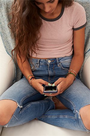simsearch:400-08892368,k - Teenage girl using smartphone at home, elevated view Stock Photo - Budget Royalty-Free & Subscription, Code: 400-08892312