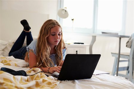 simsearch:400-08892339,k - Teenage girl using laptop lying on her bed Stock Photo - Budget Royalty-Free & Subscription, Code: 400-08892331