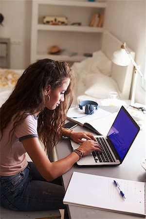 simsearch:400-06097939,k - Teenage girl using laptop at a desk in her bedroom, vertical Foto de stock - Super Valor sin royalties y Suscripción, Código: 400-08892355
